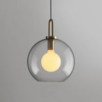 Clear glass sphere pendant light hanging over a table, 30 cm
