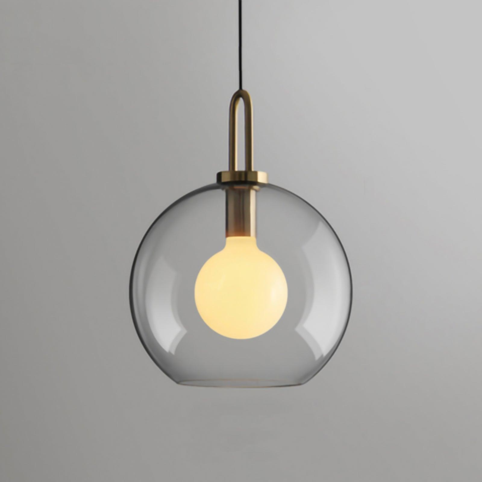 Clear glass sphere pendant light hanging over a table, 30 cm