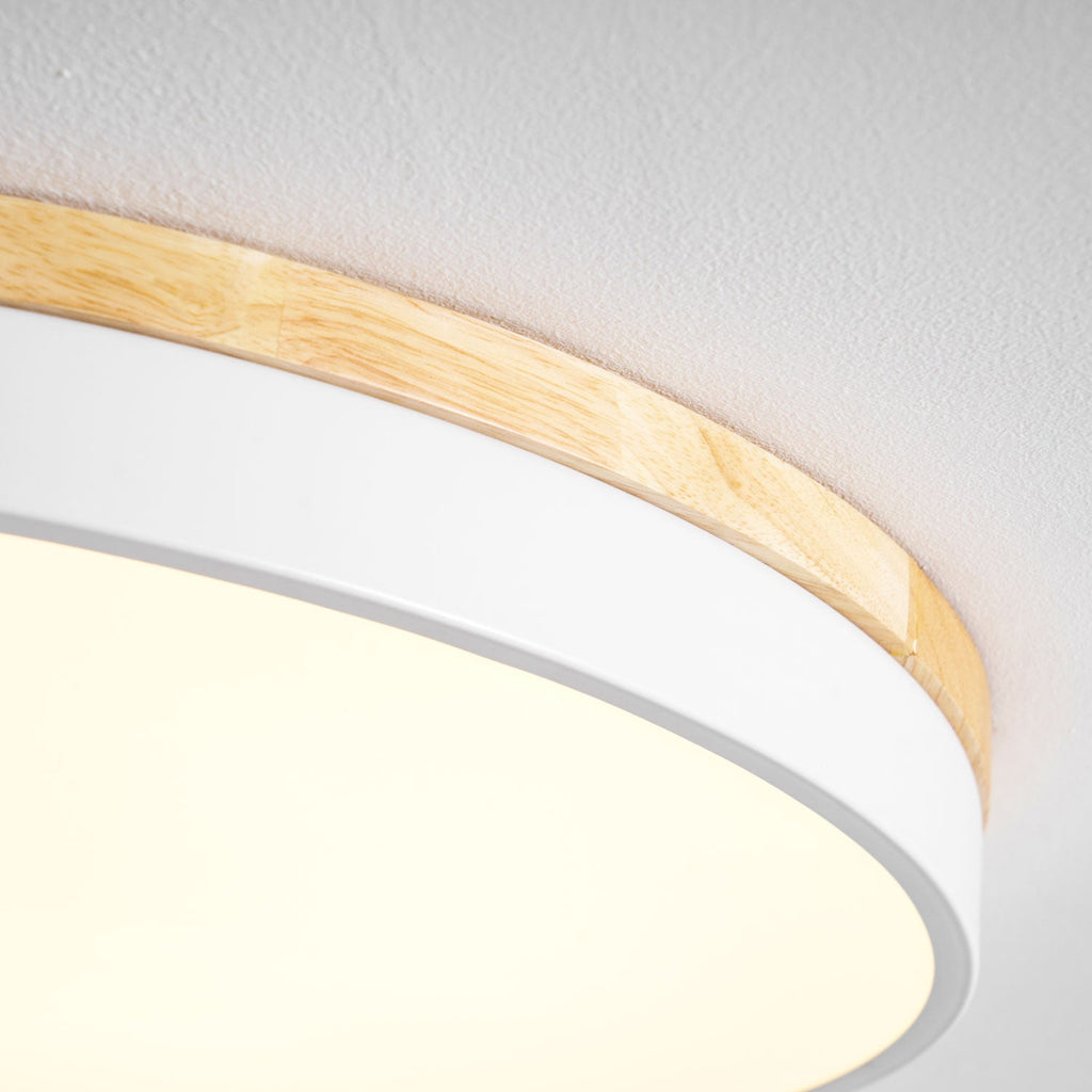 Circular wood ceiling lamp lit gently above a relaxed living area