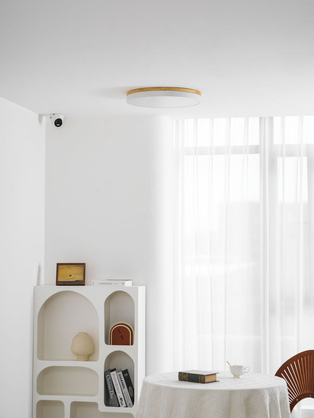 Circular wood ceiling lamp in a grey finish on a bright ceiling