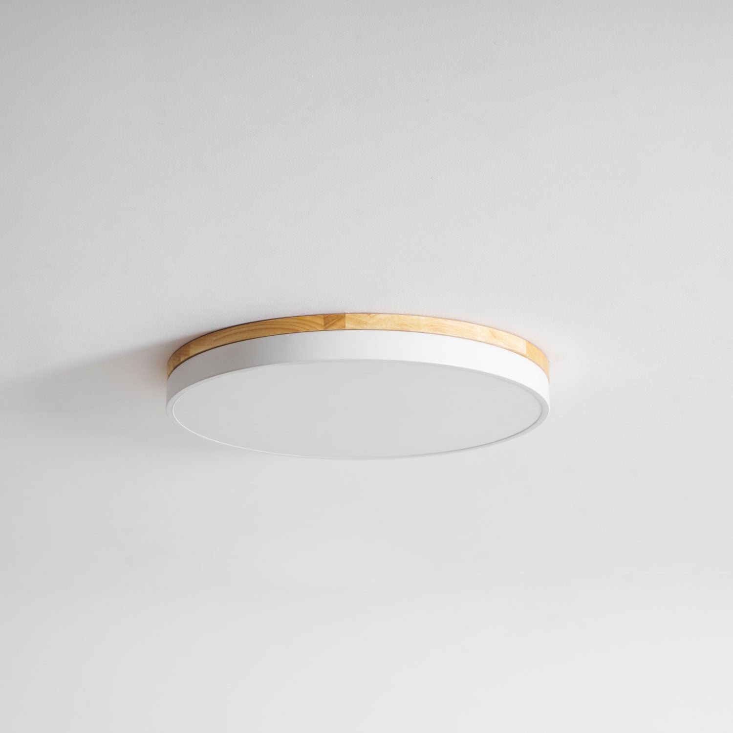 Circular wood ceiling lamp mounted in a contemporary open-plan room