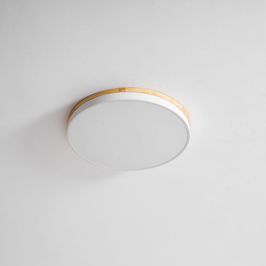 Circular wood ceiling lamp casting soft light over a neutral interior
