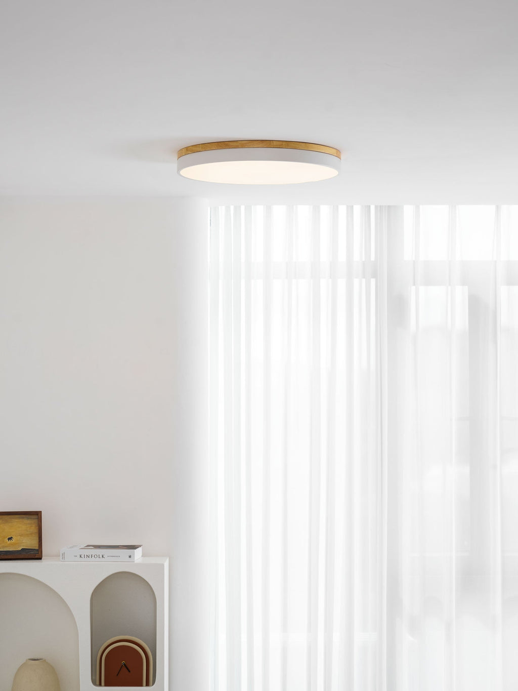 Circular wood ceiling lamp illuminating a hallway with soft white light