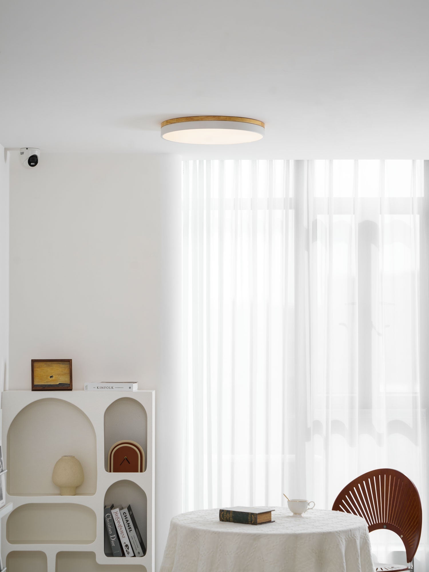 Circular wood ceiling lamp seen at an angle showing the slim depth