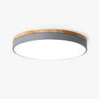 Circular wood ceiling lamp glowing softly in a calm bedroom setting