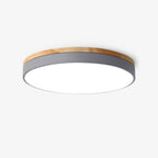 Circular wood ceiling lamp shown flush against a bedroom ceiling