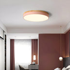 Circular wood ceiling lamp lit at night showing soft diffused glow