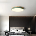 Side angle of the slim circular wood ceiling lamp against a pale ceiling