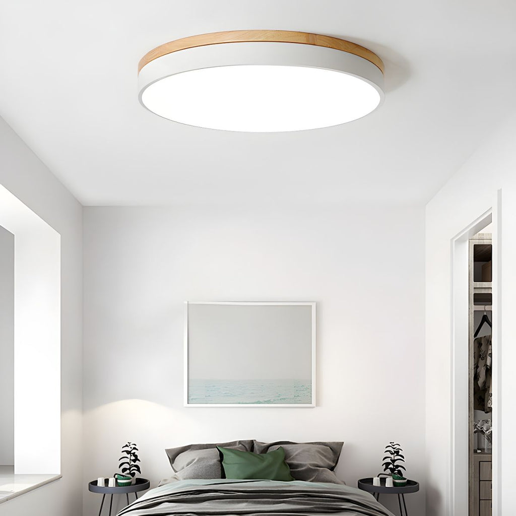 Circular wood ceiling lamp on a ceiling in a minimalist interior