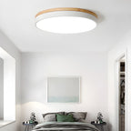 Circular wood ceiling lamp on a ceiling in a minimalist interior