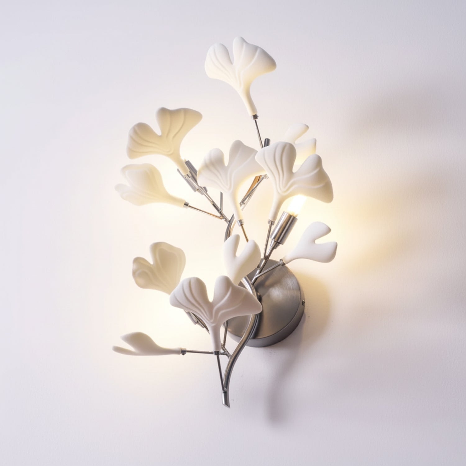 White ceramic ginkgo leaves fanned across a wall lamp