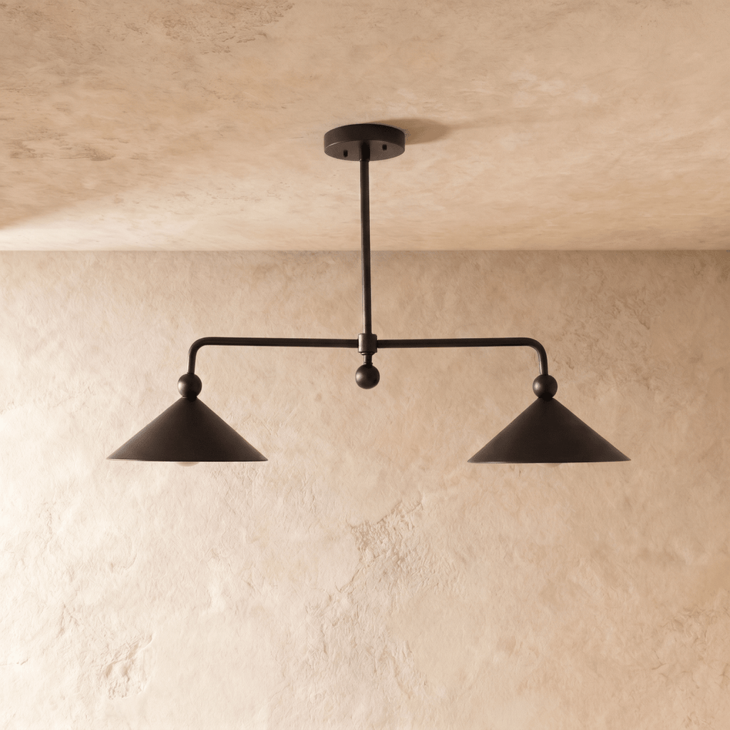 Clérachic chandelier in matte black, straight-on view of the paired cone shades lit from below.