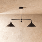 Clérachic chandelier in matte black, straight-on view of the paired cone shades lit from below.