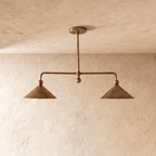 Clérachic chandelier in vintage brass, front view of the paired cone shades on their angled ceiling bar.