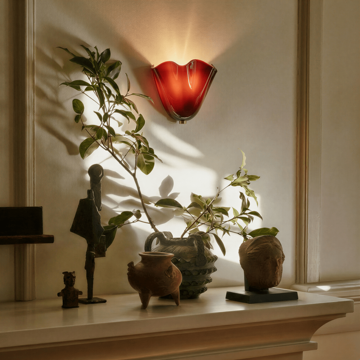 Clérachic green glass wall light casting coloured light down the wall
