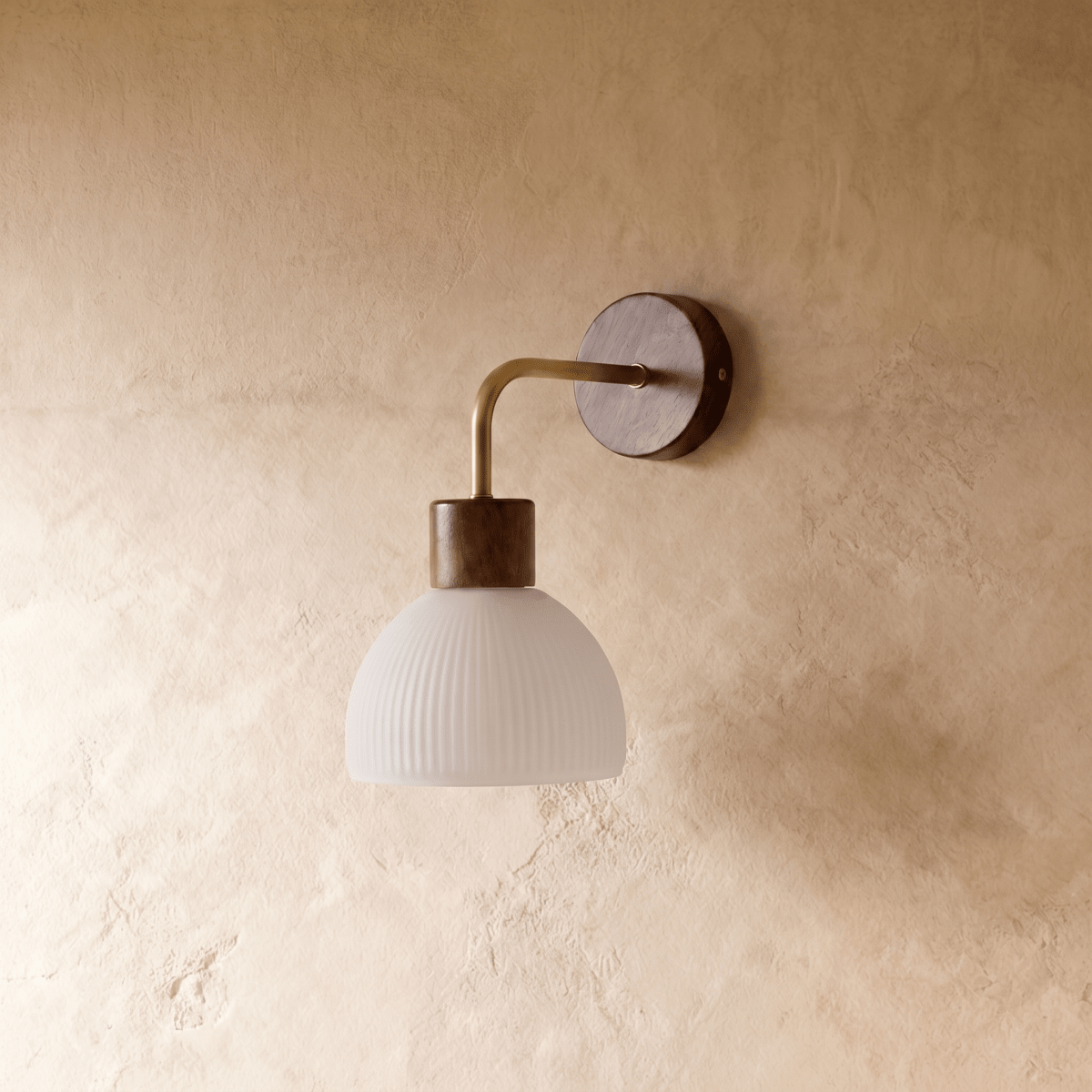 A Clérachic wall light extends a curved brass arm from a bronze base to a fluted white glass dome shade.