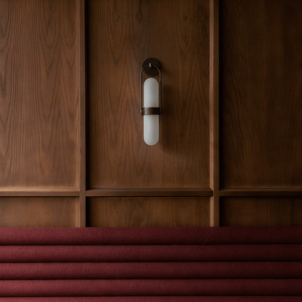 Clérachic black wall lamp switched off on dark wood panelling above a burgundy bench seat, its opal capsule flat and matte.