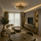 Clérachic vintage brass flush ceiling light glowing above a curved sofa and dining table in an open living room.