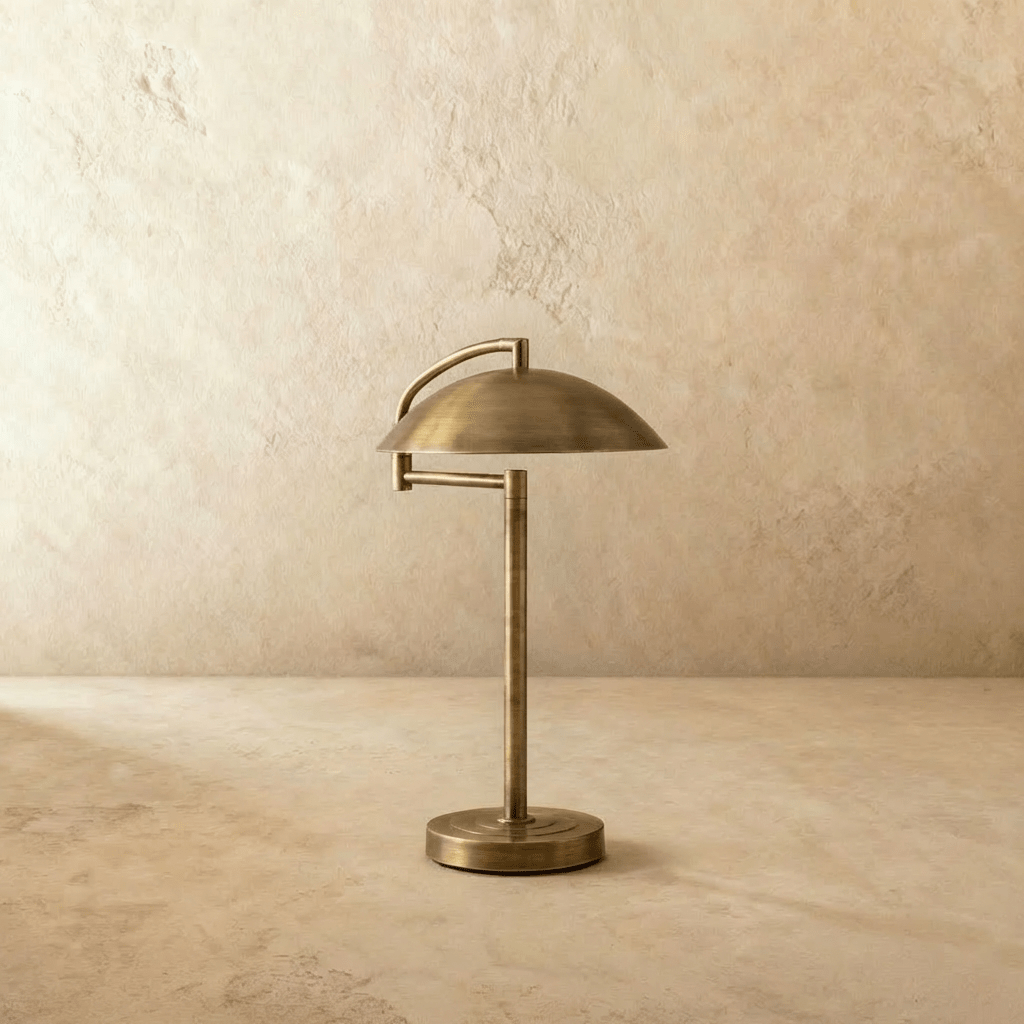 Clérachic dome table lamp in vintage brass, its shade reaching past the round base on both sides.