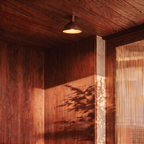 Clérachic ceiling light glowing on a wood-paneled ceiling beside a sunlit woven strand curtain.