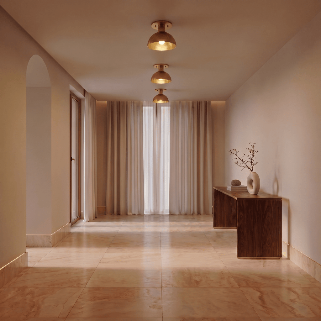 Clérachic ceiling light in brass, three fixtures spaced along a marble hallway lined with curtains.