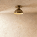Clérachic ceiling light in vintage brass, a domed metal shade mounted flush against a plaster ceiling.
