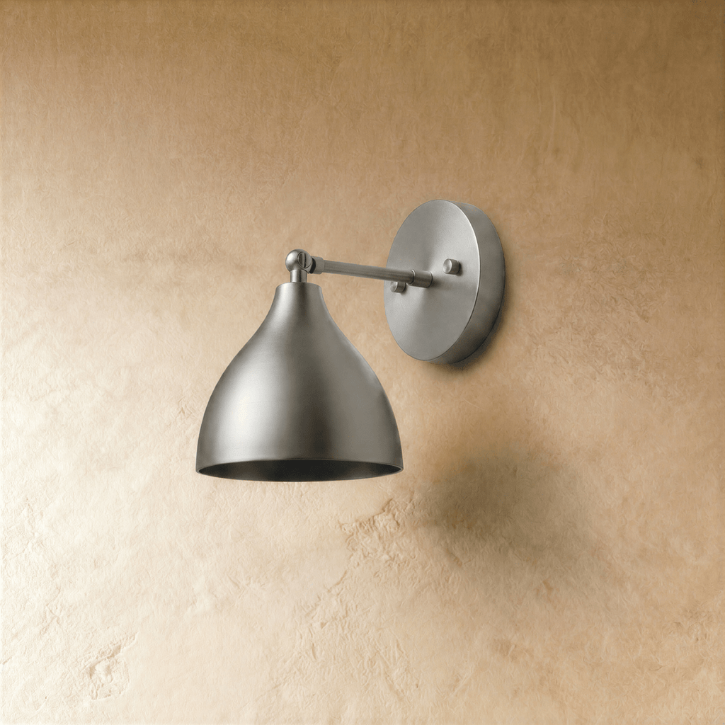 This chrome Clérachic wall lamp is shown from another angle, its bell shade tilted toward the light.