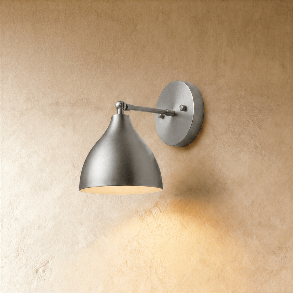 Clérachic wall lamp in chrome, its bell-shaped shade angled downward from a slim metal arm.