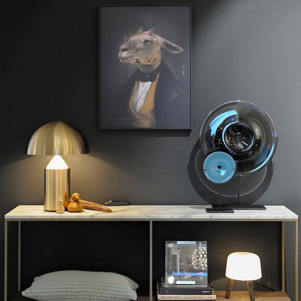 Sculptural metal table lamp glowing in a styled room