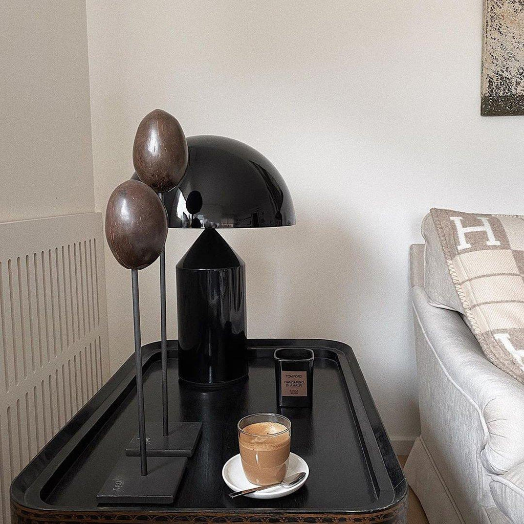 Black lamp and coffee cup on a tray in a living room setting
