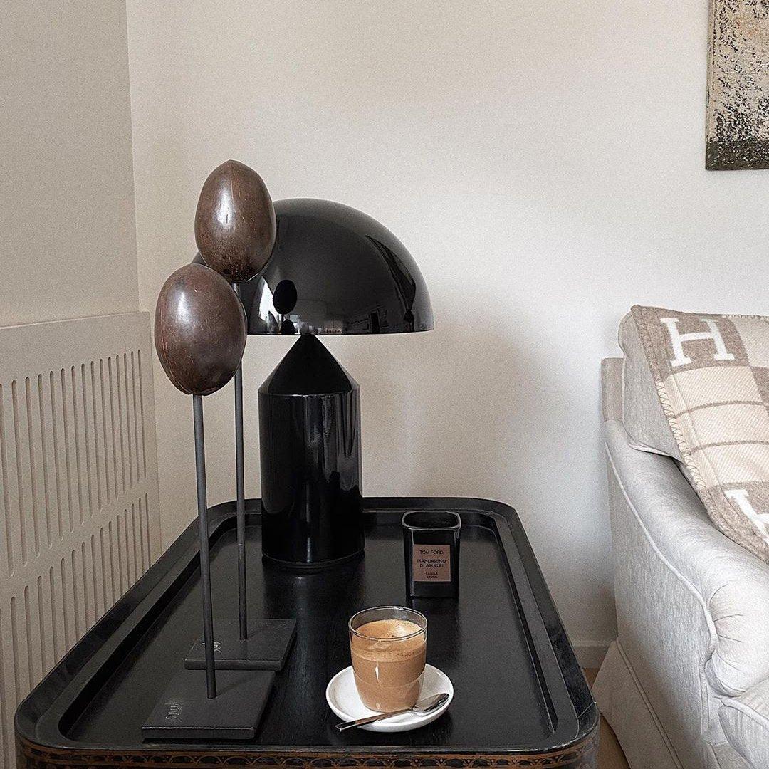 Black lamp and coffee cup on a tray in a living room setting