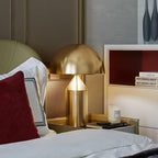 Sculptural metal table lamp glowing softly on a table