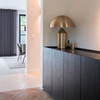 Sculptural metal table lamp casting soft light on a surface