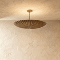 Clérachic pendant light in vintage brass, a fluted disc shade hung flat beneath a slender ceiling rod.