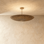 Clérachic pendant light in vintage brass, a fluted disc shade hung flat beneath a slender ceiling rod.