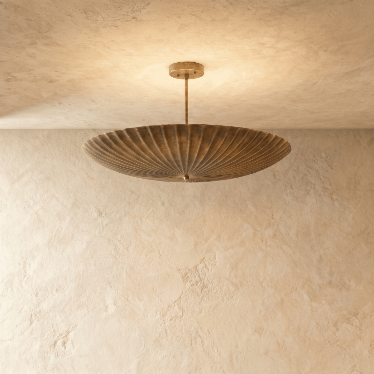 Clérachic pendant light in vintage brass, a fluted disc shade hung flat beneath a slender ceiling rod.