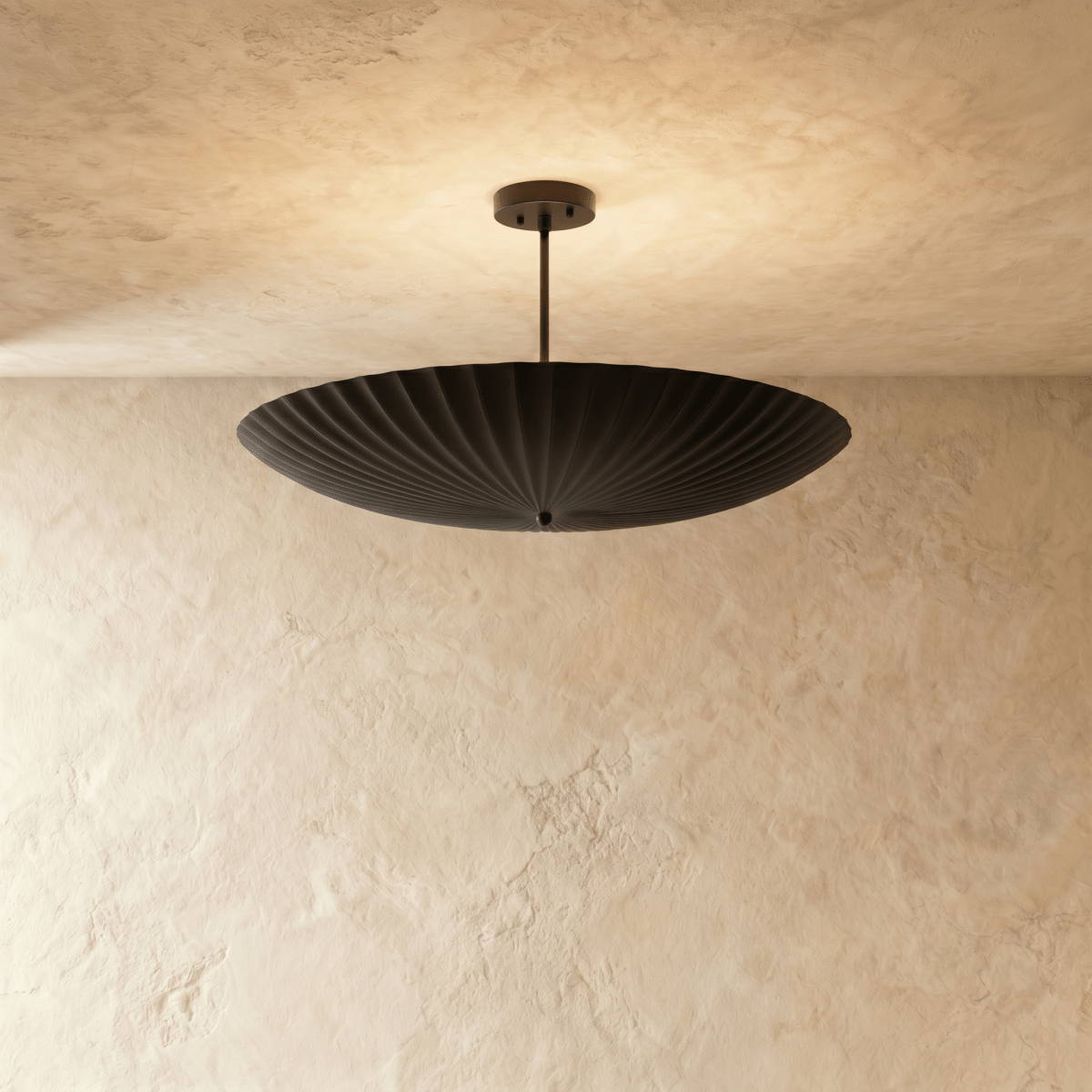 Clérachic pendant light in matte black, a fluted disc shade hung flat beneath a slender ceiling rod.