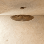 Clérachic pendant light in vintage brass, close view of the fluted disc shade and mounting canopy.