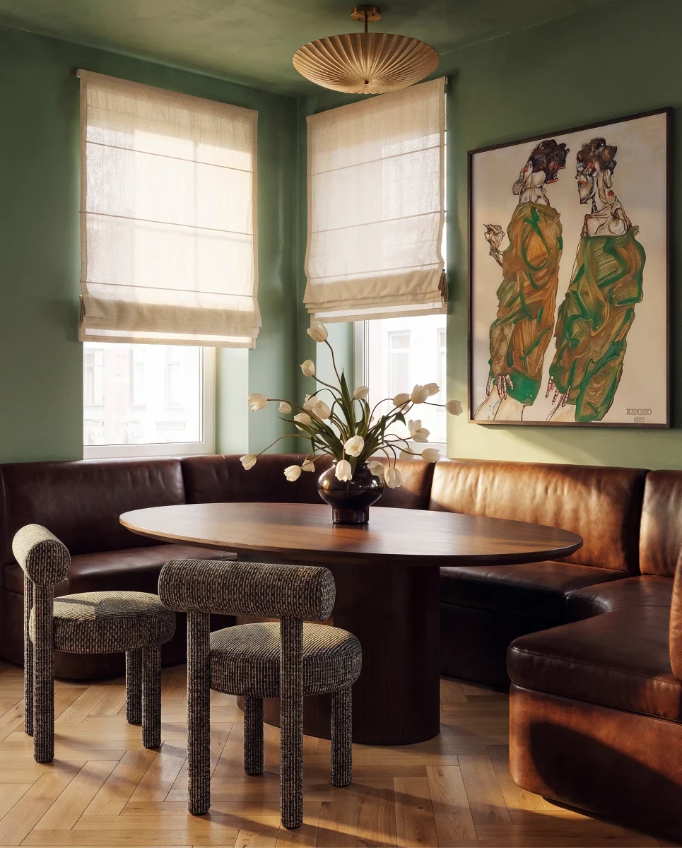Clérachic pendant light in brass hung over a breakfast nook with a leather banquette and green walls.