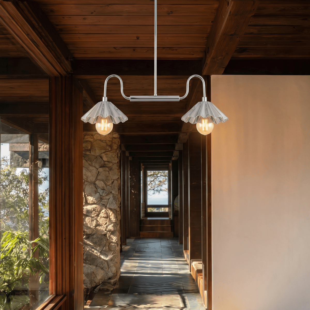 Clérachic double-arm ceiling chandelier in chrome, lighting a wood-beamed hallway beside a rough stone pillar.