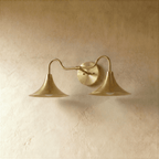 Clérachic double-head wall sconce in polished brass, the trumpet shades and gooseneck arms shown from another angle.