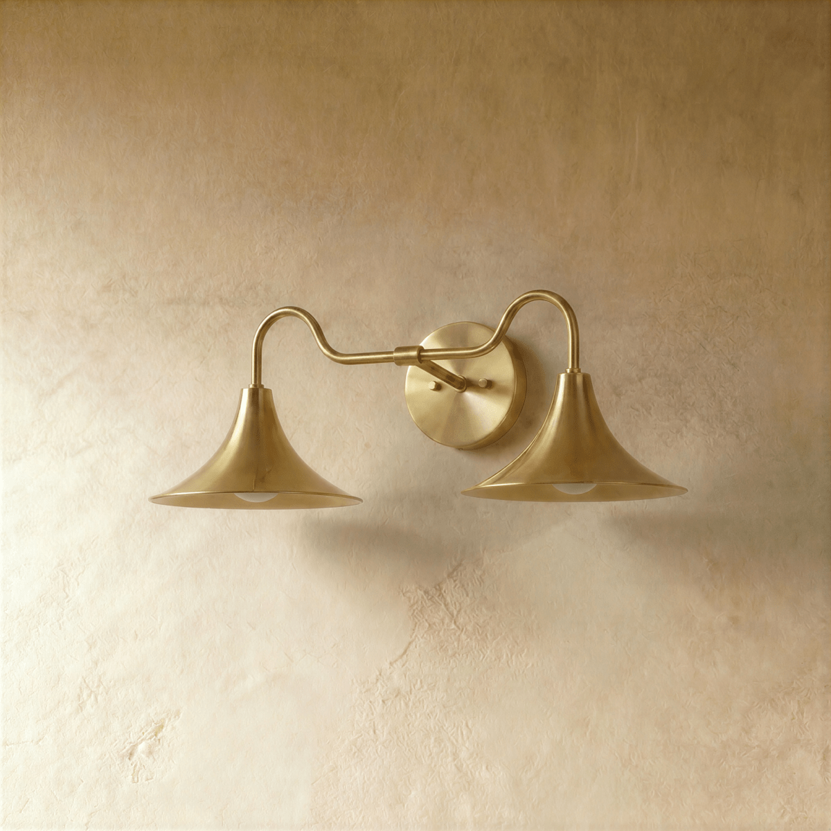 Clérachic double-head wall sconce in polished brass, the trumpet shades and gooseneck arms shown from another angle.