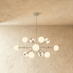 This Clérachic chandelier in chrome, a sputnik burst of opal glass globes on slender arms.