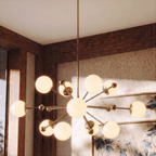 Clérachic chandelier in vintage brass glowing in a wood-paneled dining room with floral wallpaper.