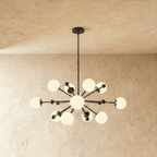 Clérachic chandelier in matte black, a sputnik burst of opal glass globes on slender arms.