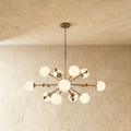 Clérachic chandelier in vintage brass, a sputnik burst of opal glass globes on slender arms.