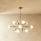 Clérachic chandelier in vintage brass, a sputnik burst of opal glass globes on slender arms.