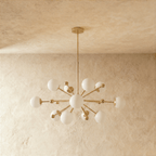Clérachic chandelier in brushed brass shown from another angle, globes radiating outward from the rod.