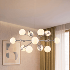 Clérachic chandelier in chrome lighting a living room corner beside sheer curtains and framed art.