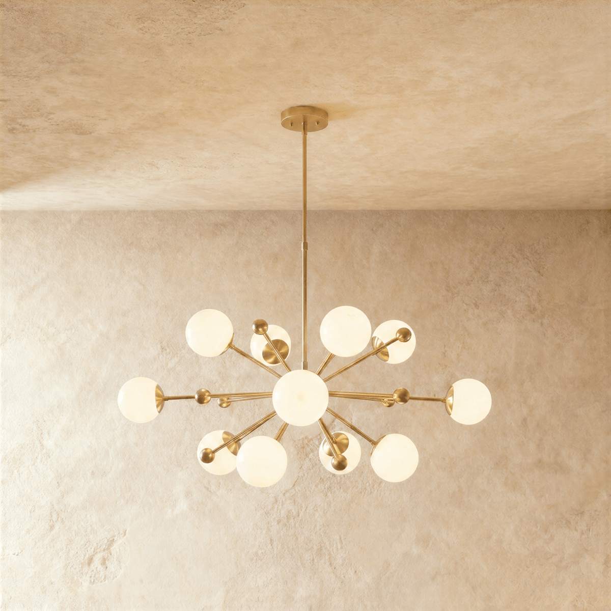 Clérachic chandelier in brushed brass, a sputnik burst of opal glass globes on slender arms.